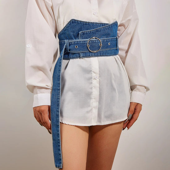 Szeroki jeansowy pas gorsetowy Dakota na modelce, modelujący talię, z dużą okrągłą klamrą i długim paskiem. Idealny do stylizacji.